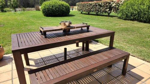 a wooden picnic table with a grill on top of it at Chez Vous French Cottage - Pokolbin Hunter Valley! in Pokolbin