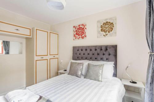 1 dormitorio con 1 cama grande con sábanas y almohadas blancas en The Summit Apartment Aberdeen City Central Perfect Short or long stay en Aberdeen