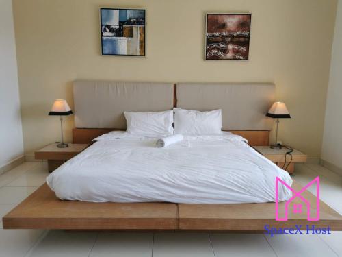 a bedroom with a large white bed with two lamps at Gold Coast Morib Resort in Banting