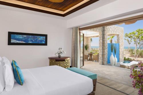 a bedroom with a white bed and a patio at Banana Island Resort Doha by Anantara in Doha