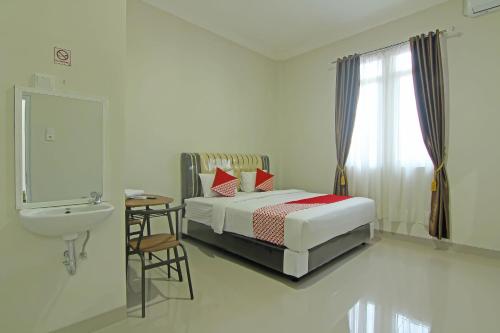 um quarto com uma cama, um lavatório e um WC em Capital O 91675 Utama Residence em Padang