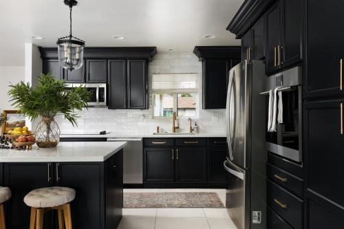 a kitchen with black cabinets and a refrigerator at South Scottsdale w/ Chef's Kitchen & Golf Nearby!! in Scottsdale