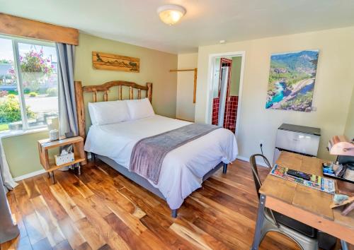 a bedroom with a bed and a desk in it at Evergreen Motel in Libby