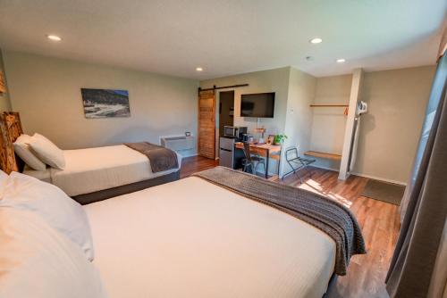 a hotel room with two beds and a desk at Evergreen Motel in Libby