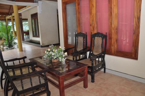 a dining room with chairs and a table with flowers on it at Mount Crest Inn Deniyaya in Deniyaya