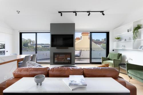a living room with a couch and a fireplace at Barangaroo Park Apartments by Urban Rest in Sydney