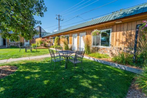 a table and chairs in a yard next to a building at Evergreen Motel in Libby