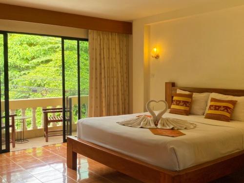 a bedroom with a bed and a balcony at Kata View Guest House in Kata Beach