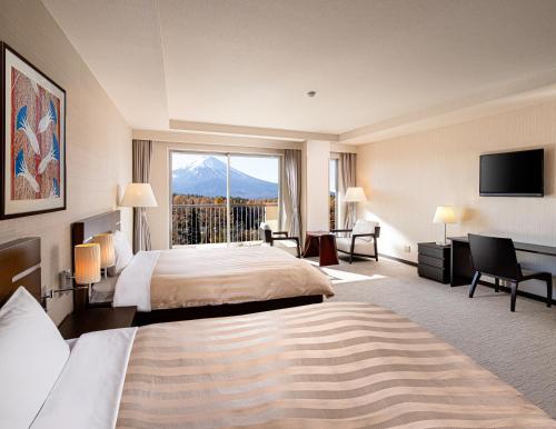 a hotel room with a bed and a large window at The Gran Resort Princess Fujikawaguchiko in Fujikawaguchiko