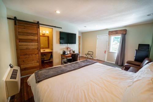 a bedroom with a large bed and a television at Evergreen Motel in Libby