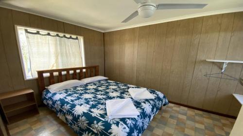 Un dormitorio con una cama azul y blanca y una ventana en Jurien Bay View Bungalows Jetty View 5, en Jurien Bay