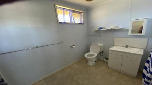 Baño blanco con aseo y lavamanos en Jurien Bay View Bungalows Jetty View 5, en Jurien Bay