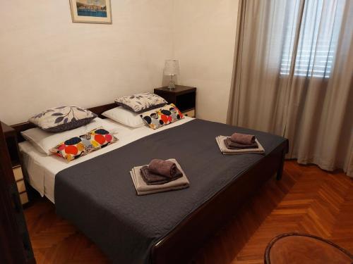 a bedroom with a bed with towels on it at Apartment Silvana - 100 m from beach in Božava