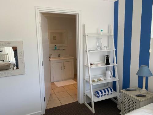 Pokój z białą półką i łazienką w obiekcie Chez Pierre w mieście Knysna