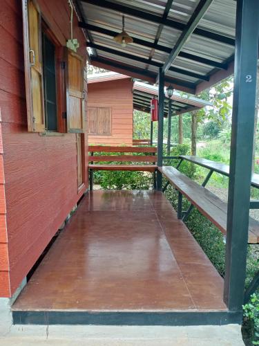 a porch with two benches on the side of a building at Sleep & fishing Pua in Nan