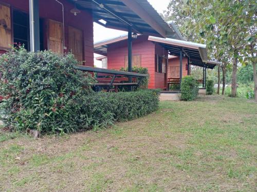 a red house with a picnic table in front of it at Sleep & fishing Pua in Nan