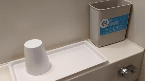 a white counter with a box next to a sink at Toyoko Inn Nishitetsu Kurume eki Higashi guchi in Kurume