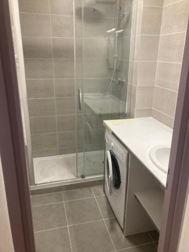 een badkamer met een douche en een wasmachine bij La Moucherolle in Villard-de-Lans