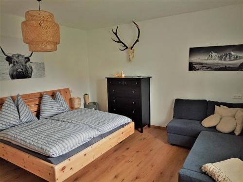 a bedroom with a bed and a blue couch at Family Home Weißensee in Greifenburg