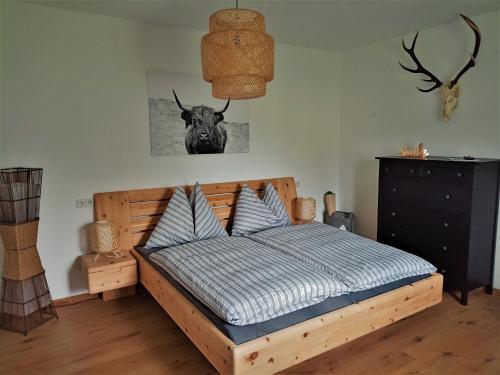 a bedroom with a wooden bed with a bull head on the wall at Family Home Weißensee in Greifenburg