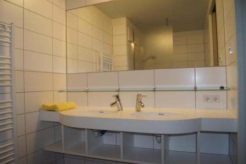 ein Bad mit einem Waschbecken und einem Spiegel in der Unterkunft Hostel-Jugendherberge St. Johann im Pongau in St. Johann im Pongau