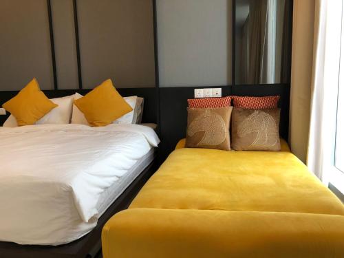 吉隆坡的住宿－Tropicana The Residences KLCC by StayHere，一间卧室设有两张带黄色垫子的床。