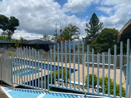 a white picket fence next to a swimming pool at Finca Villa Maju K24 Vista naturaleza clima delicioso A 30 min Cali in Papagalleros
