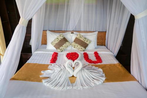 a bed with two swans made out of flowers at KiBata Lembongan Boutique Hotel in Nusa Lembongan