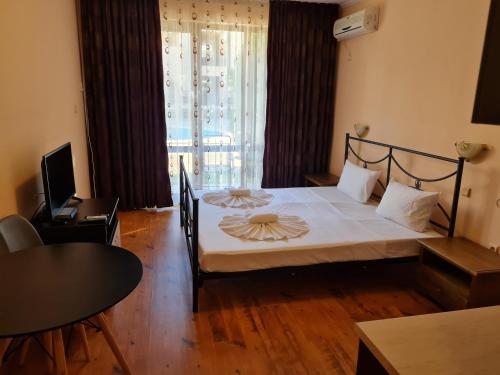 Un dormitorio con una cama grande y una mesa. en MitProt Panorama Bay 2 ap 30, en Sveti Vlas