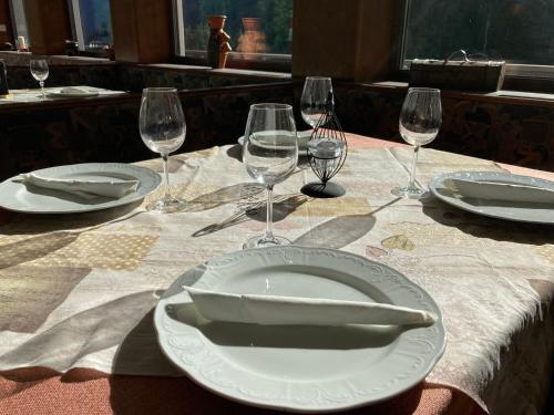 a table with a plate and wine glasses on it at Gasthof Lublass in Matrei in Osttirol