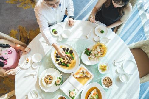 a group of people sitting at a table eating food at Zenith Hotel Putrajaya in Putrajaya
