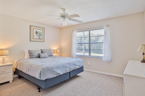 a bedroom with a bed with a ceiling fan and a window at Seaside Getaway in St. Augustine