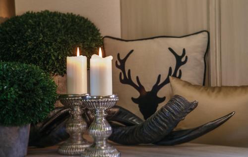 a candle holder with two candles on a table with antlers at Boutiquehotel Säumler in Zell am Ziller