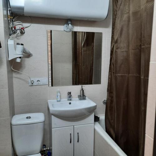 a bathroom with a sink and a toilet and a mirror at Отдельная Квартира со всеми удобствами in Chişinău