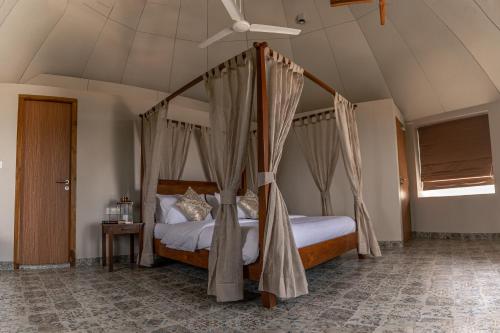 a bedroom with a canopy bed with a ceiling fan at LOTUS VILLA in Chennai