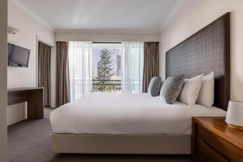 a hotel room with a large bed and a window at Mantra Crown Towers in Gold Coast