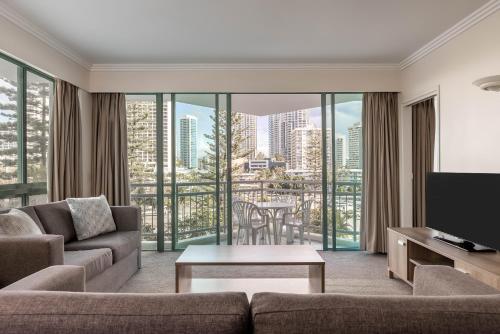 sala de estar con sofá y TV en Mantra Crown Towers, en Gold Coast