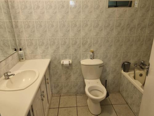 uma casa de banho com um WC branco e um lavatório. em Margate Beachfront Apt for 6 adults 2 kids em Margate