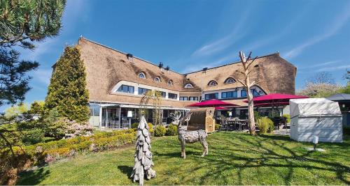 a large brick building with a animal in the yard at NP Hotel Wittenbeck in Kühlungsborn