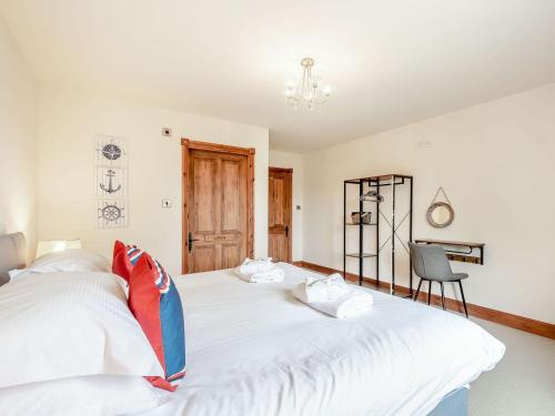 a bedroom with two beds and a chair at Seaviews And Hot Tub At Admirals Anchor in Portpatrick