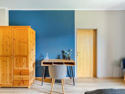 a dining room with a table and a blue wall at Das Schider - Boutique Apart-Hotel in Bad Gastein