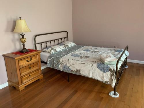 a bedroom with a bed and a lamp and a dresser at Beautiful Victorian house, Room in Boston