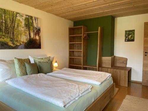 una camera da letto con un grande letto con una parete verde di Holzhauser Hof a Waldkraiburg