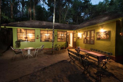 a house with a table and chairs outside at night at Grassroots Wayanad, Valley-view Tents in Vythiri
