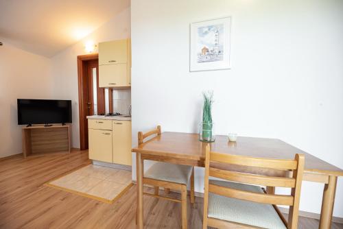 una cucina e una sala da pranzo con un tavolo e una televisione di Villa Heaven Apartment - Airport Zadar a Donji Zemunik