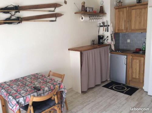 - une petite cuisine avec une table et une table dans l'établissement APPARTEMENT LA FOUX D'ALLOS, à La Foux