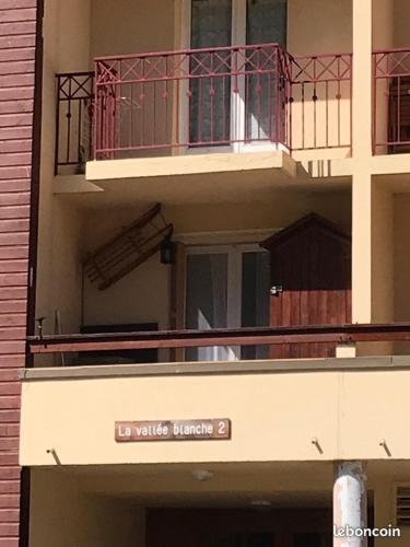 - un bâtiment avec un balcon muni d'un panneau dans l'établissement APPARTEMENT LA FOUX D'ALLOS, à La Foux