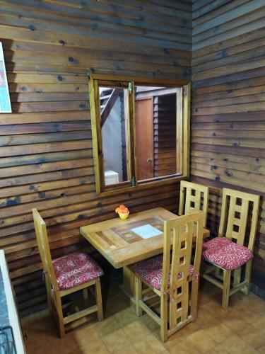 a wooden table and chairs in a log cabin at Lele Panchito y Lavanda Juntos en el Centro in Querétaro