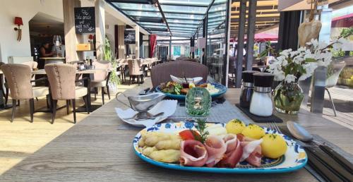 a wooden table with two plates of food on it at NP Hotel Wittenbeck in Kühlungsborn