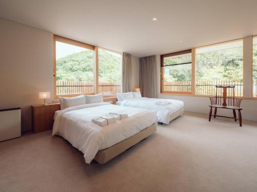 a large bedroom with two beds and windows at Hatago Vison 